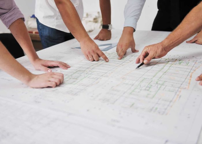 Architects and engineers pointing at design plans